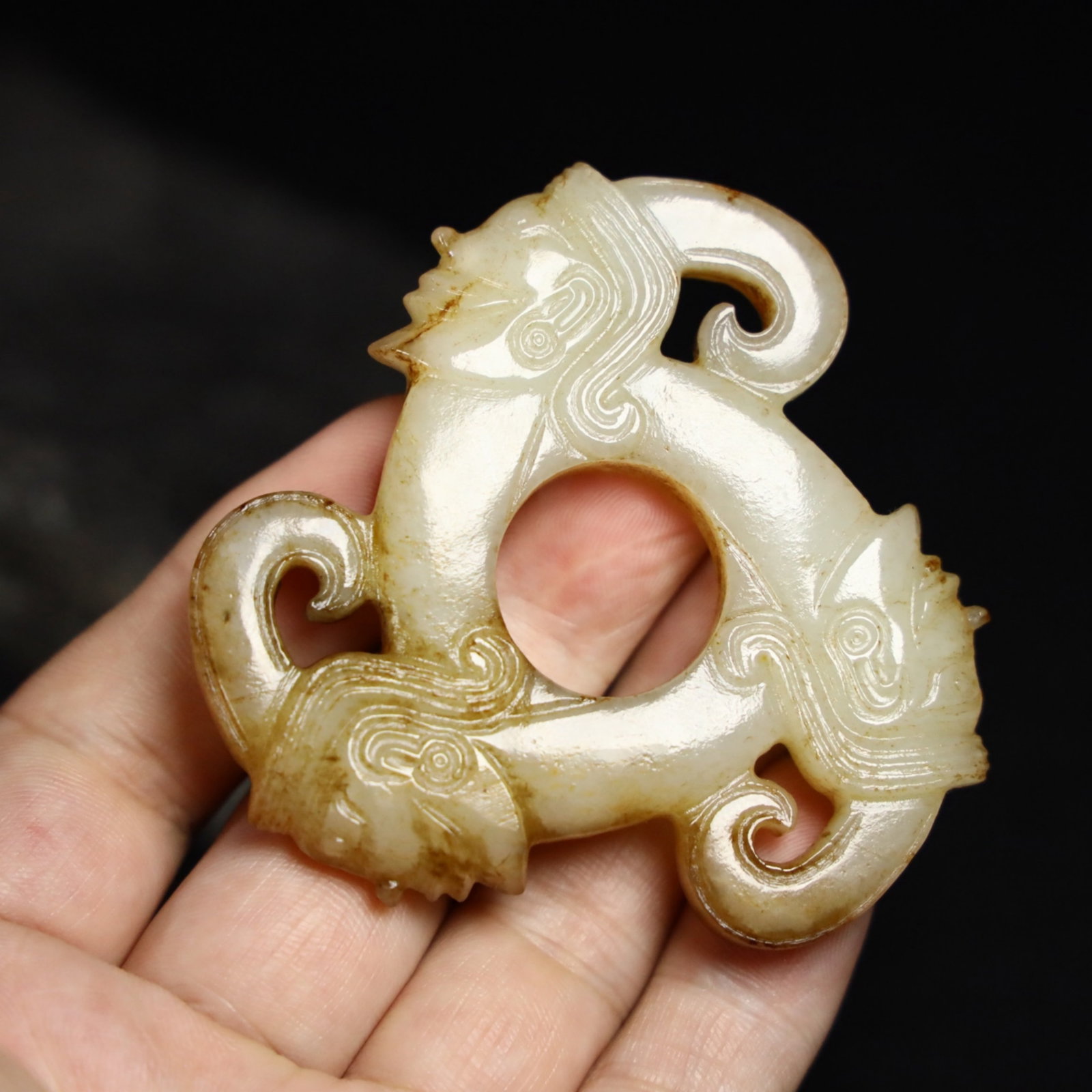 A Chinese Carved Jade Man Heads Pendant: Lg. 7.1cm, Wd. 1cm, Wt. 66g