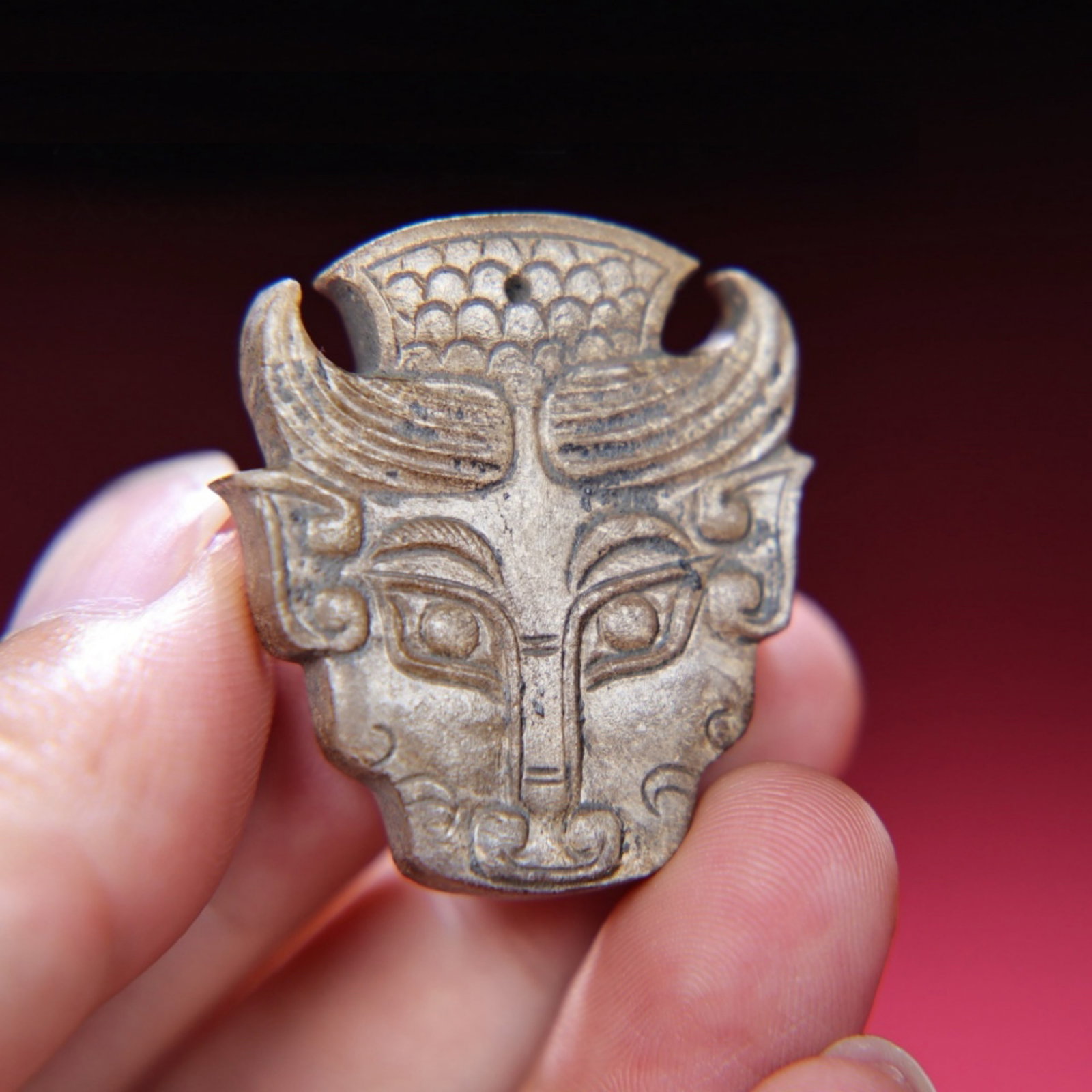 A Chinese Carved Jade Foo-Dog Head Pendant: Ht. 3.3cm, Wd. 3.8cm, Th. 0.6cm, Wt. 16g