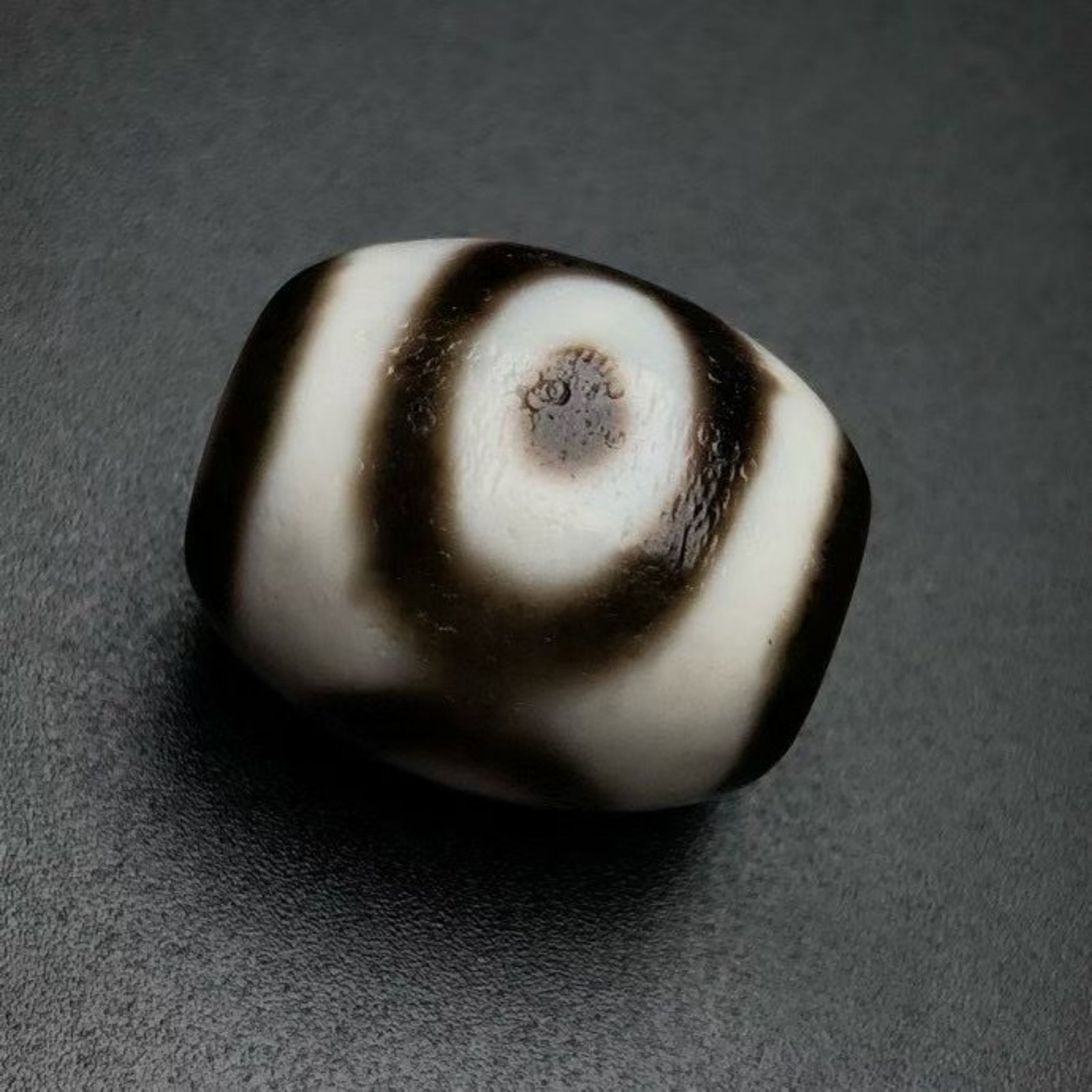 A Chinese Carved Agate DZI Bead: Lg. 2.2cm, Diam. 1.8cm, Wt. 11.7g