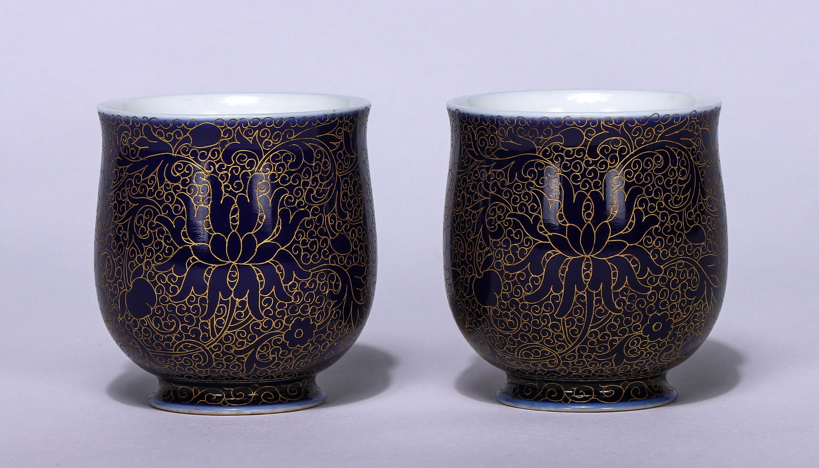 PAIR OF CHINESE BLUE GROUND GOLD-PAINTED PATTERNS CUPS: H. 6.2 cm. W. 6 cm.
