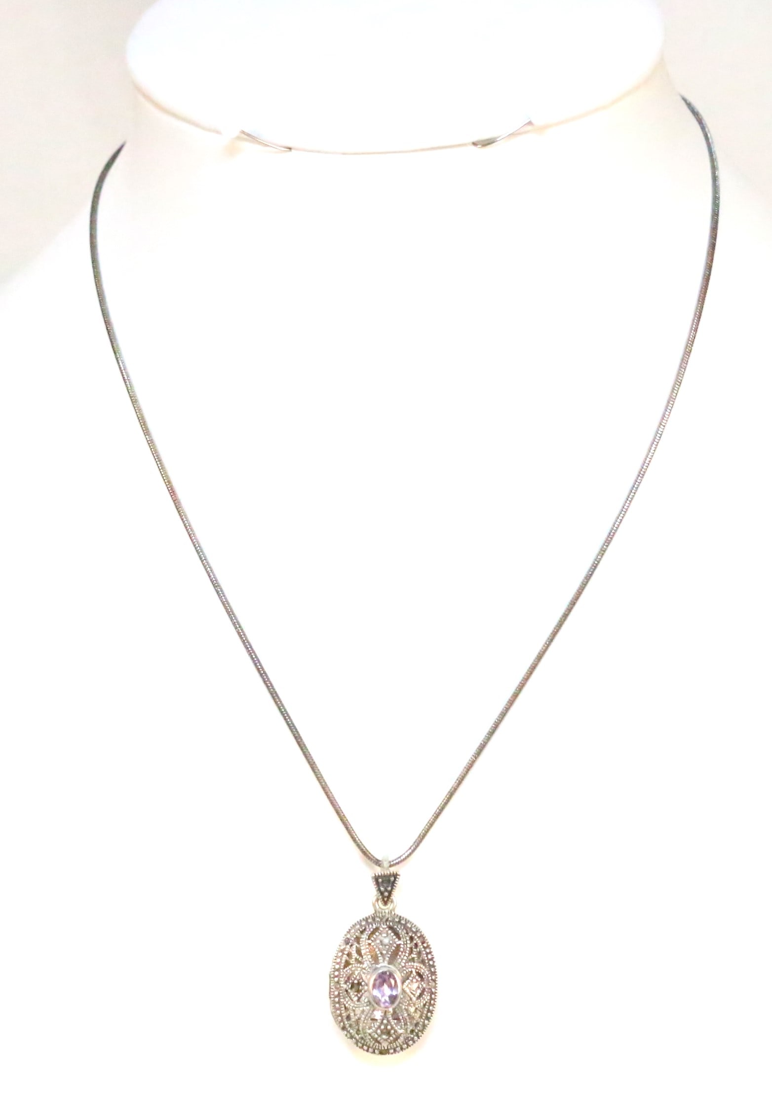 Sterling Silver filigree lavender quartz locket necklace: Stamped FAS 925 THAILAND INSIDE the locket. Lovely filigree oval locket with purple center stone on a sterling silver chain. Chain measures: 16" long. Locket is 1-1/2" long x 5/8" wide. Weighs 10. gra