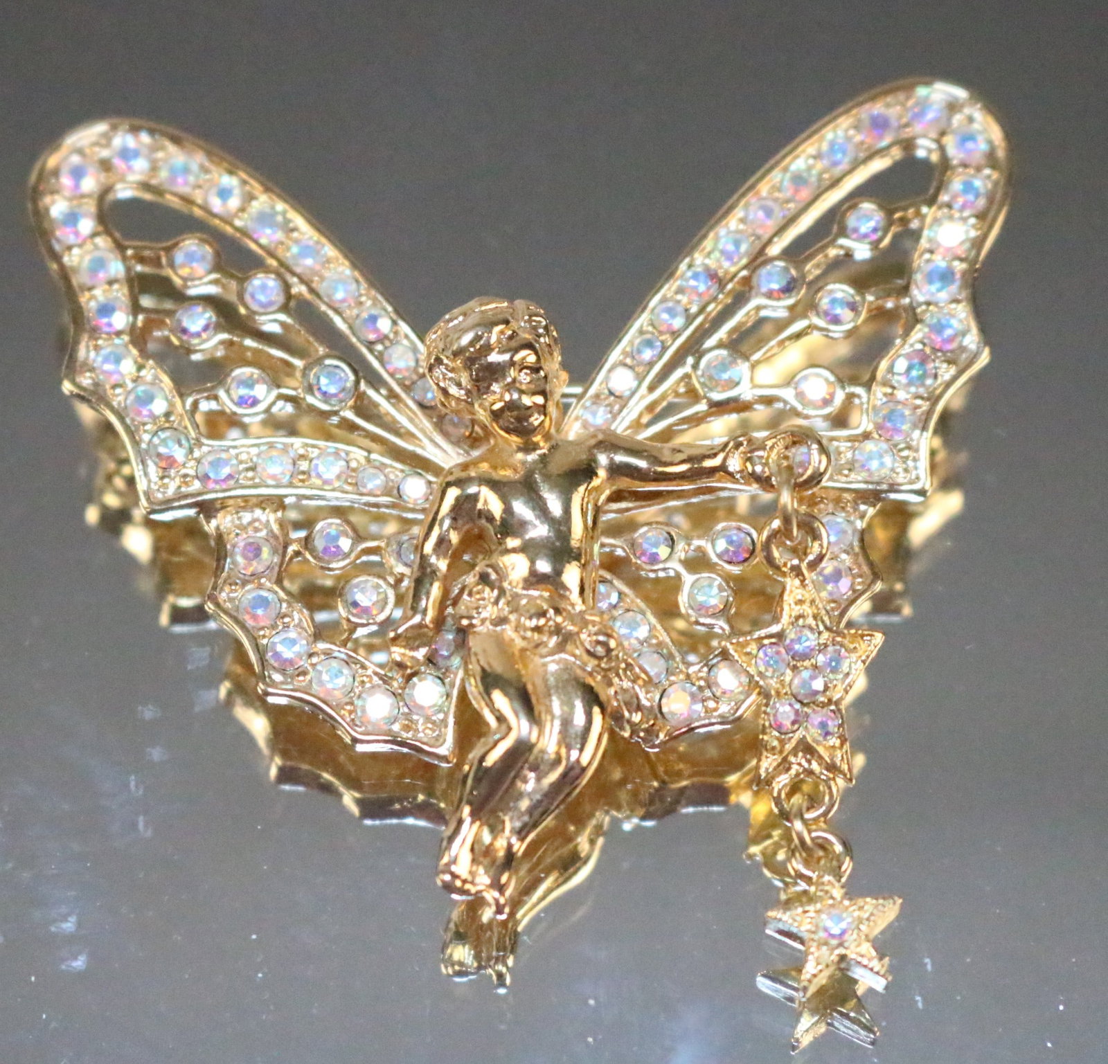 New Kirks Folly Angel Cherub Fairy Brooch stars Crystal: Stamped: Kirks Folly. Shiny Gold tone with AB Crystals. Dangling stars from the cherub hand. DIMENSIONS: 2-1/4" x 2-1/4".
