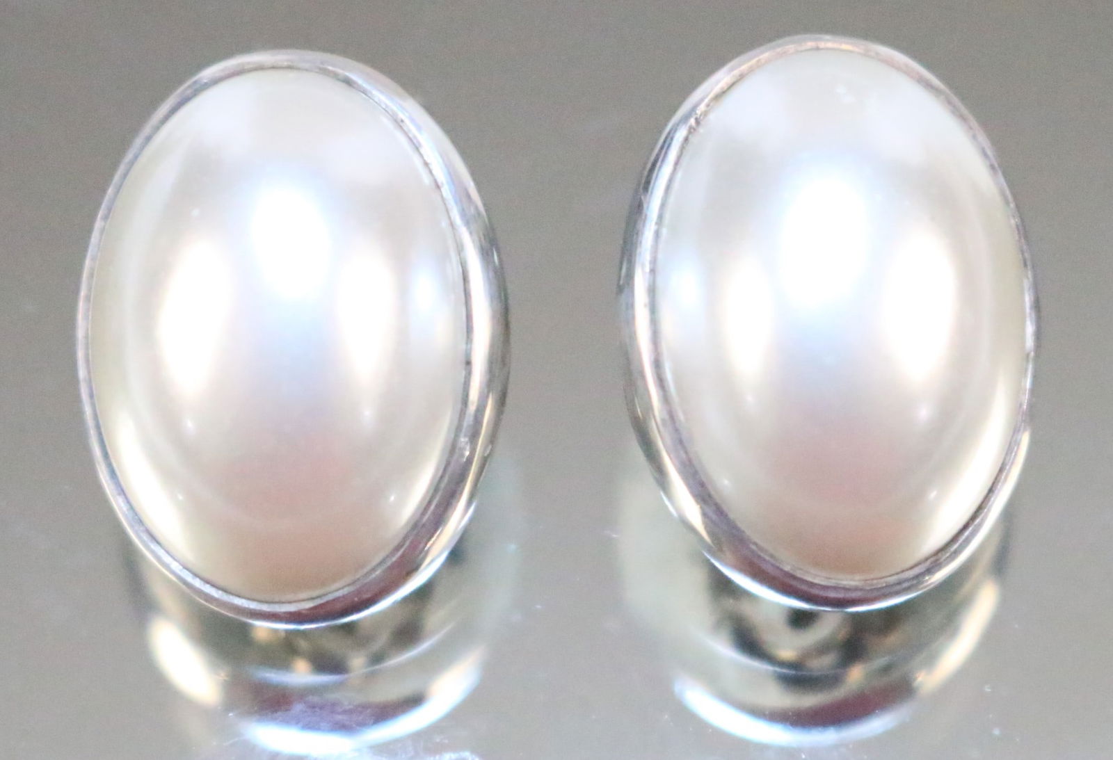 Stephen Dweck Sterling Silver One of a Kind Mabe Pearl Earrings: STAMPED: Stephen Dweck 110 2004 Sterling One of a Kind DETAILS: Lovely lustrous white oval mabe pearls set in sterling silver clip backs. DIMENSION: 3/4" long x 1/2" wide. WEIGHT: 7.4 grams.