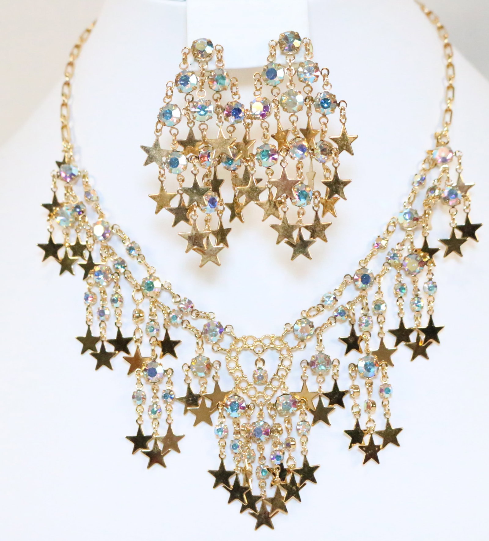 NEW RARE Kirks Folly Gold tone Stars Heart Crystal Necklace & Earring set in box: DESCRIPTION: New Vintage Old Stock. In the original kirks folly box. Necklace and matching earrings set. Loaded with Stars and Crystals. Necklace has a heart center. Pierced earrings. Signed KIRKS FOL