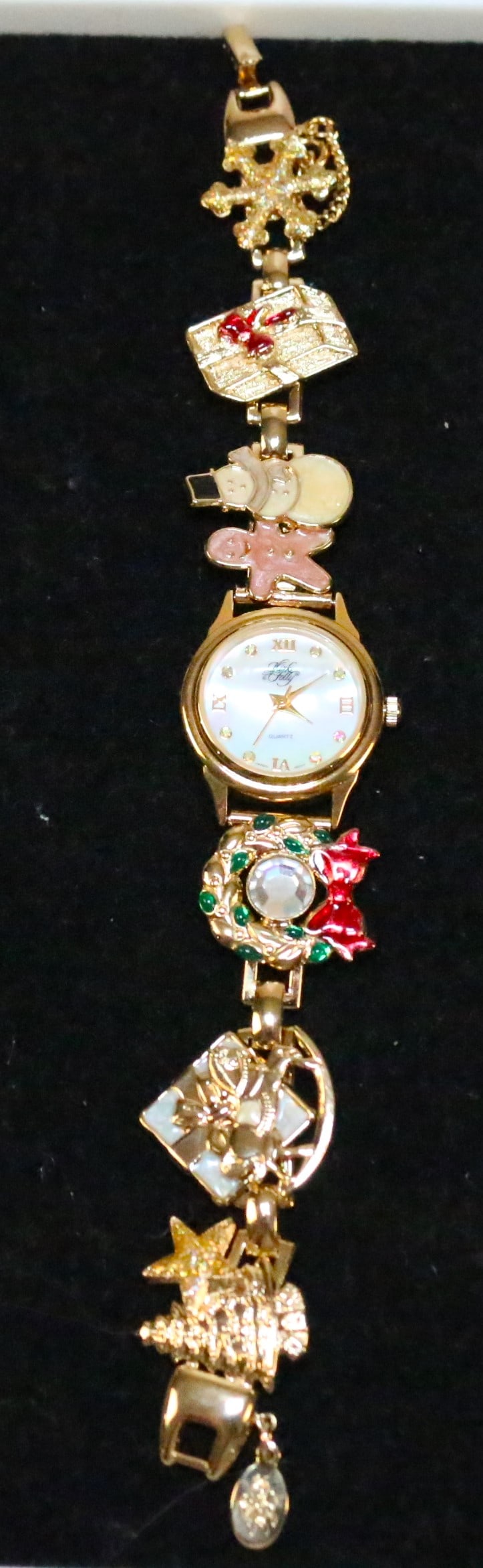 NEW RARE Kirks Folly gold tone Christmas Charm Watch in box 7.5": DESCRIPTION: RARE BRAND NEW IN THE BOX WITH ALL PAPERWORK. Mother of pearl face. Wreath, rocking horse, gifts, snowmen, snowflake, tree stars and gingerbread man. Safety chain. New battery installed. 
