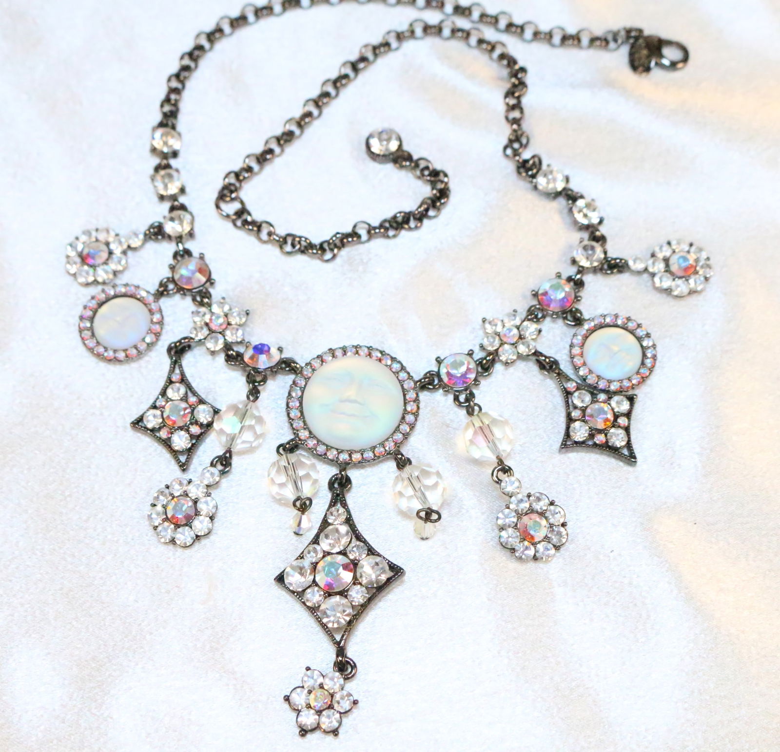 NEW Kirks Folly Seaview moon Faces Rhodium crystal Necklace: DESCRIPTION: Signed Kirks Folly. 3 Seaview moon faces surrounded by ab crystals. with dangle draped pendant and large crystals. DIMENSIONS: Can be worn 17"-20" with chain extender. Drop part of neckla
