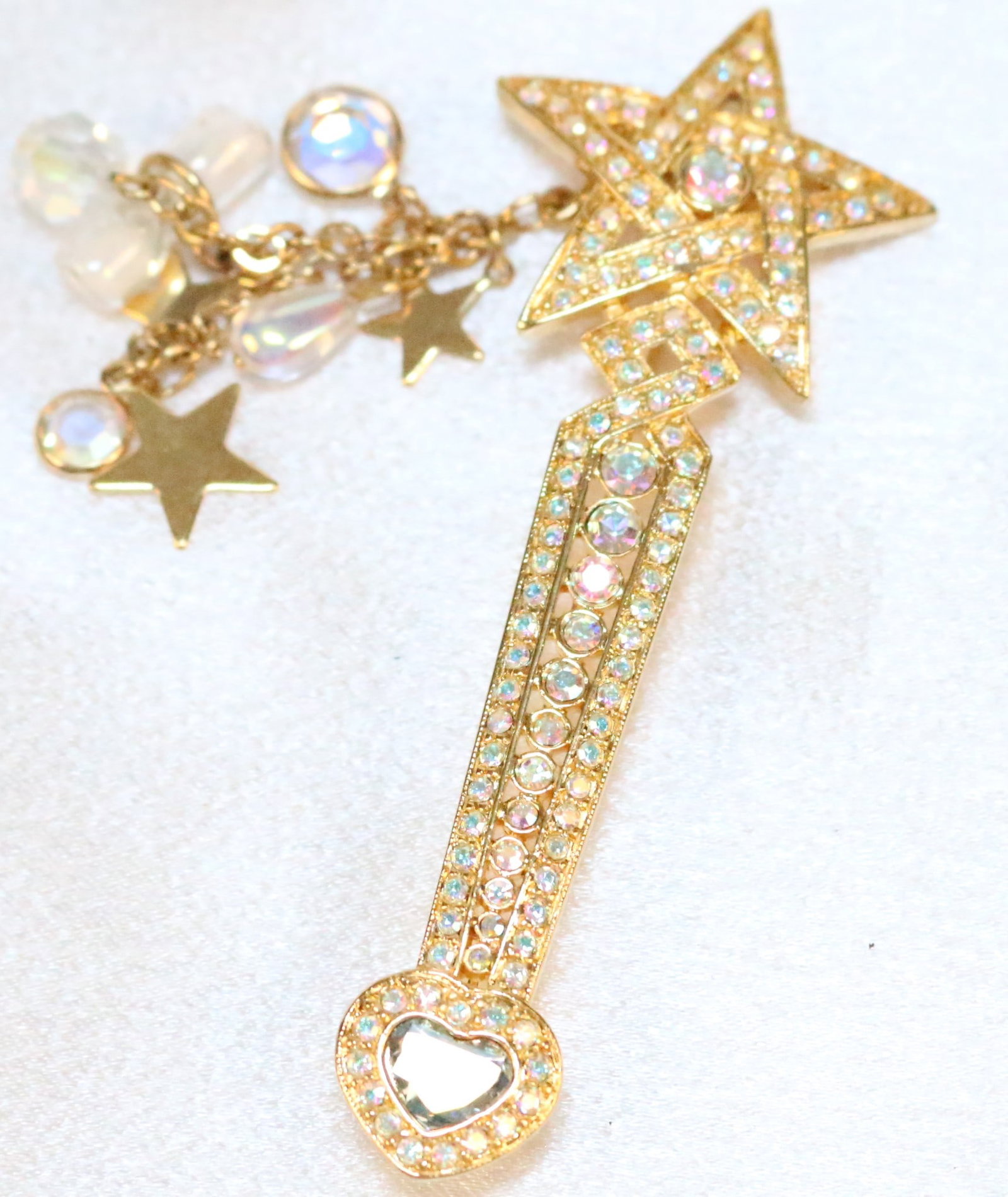 Kirks Folly Long Magic Star Wand Scepter gold tone AB crystals: DESCRIPTION: Fully paved crystals AB with heart stars and lobster clasp attached stars and crystals. Signed Kirks Folly. DIMENSIONS: Wand is 3.5" long. Charms 2.25" long.