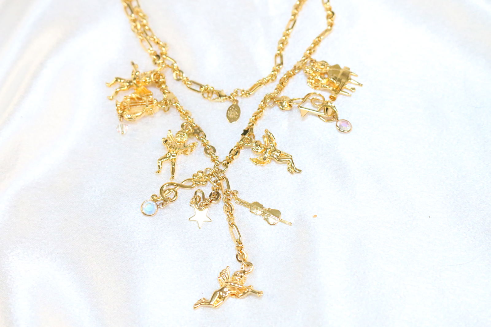 Kirks Folly bright gold tone musical angel cherub charm necklace: DESCRIPTION: Signed Kirks Folly. Harps, cherubs, angels, instruments. DIMENSIONS: Chain is 30" plus longest drop charm cherub is 2.75".