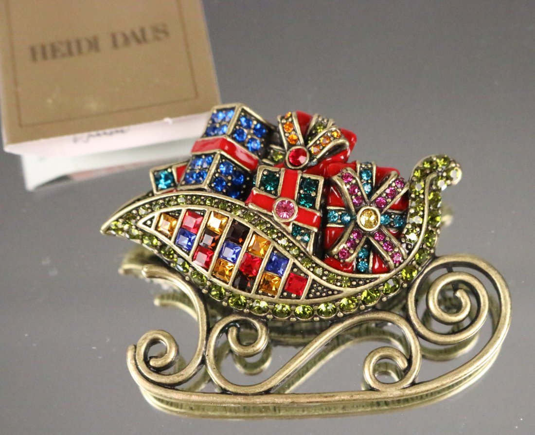 NEW HEIDI DAUS "You Sleigh Me" Christmas Sleigh full of gifts brooch pin: DESCRIPTION: NEW AMAZING Colorful brilliant crystals accented by enamel ribbon and brass bronze tone sleigh runner. Perfect for Christmas and Holiday gift giving. MEASUREMENT: 2.5" long x 2" high. Hal
