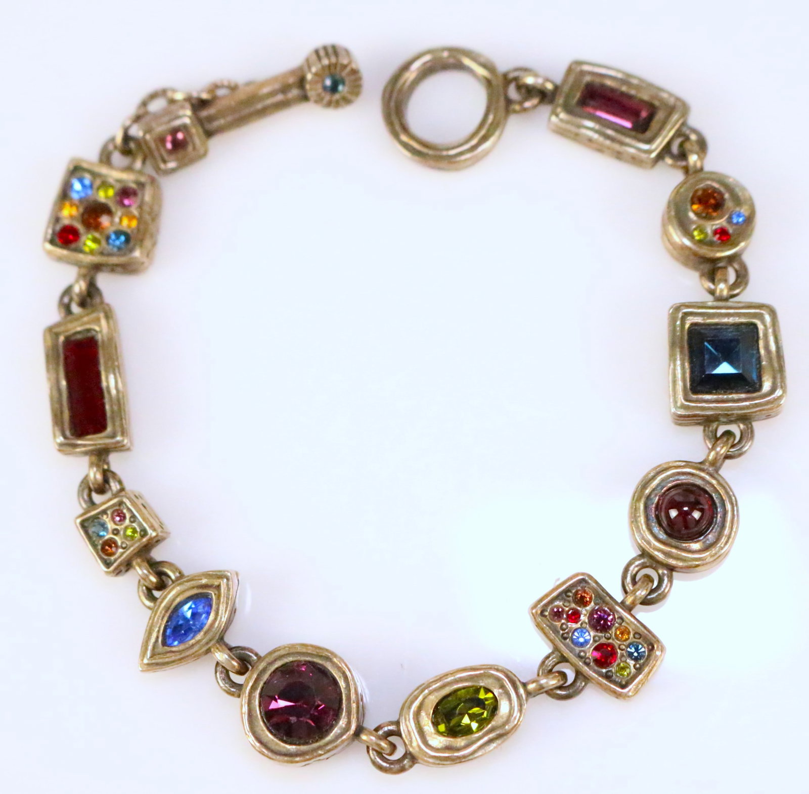 Patricia Locke USA Jewelry Designer Multicolor geometric modernist Toggle bracelet: Beautiful antique gold finish toggle bracelet with multicolor size and shape colorful gemstones in etched designs. Measures: 7.75" long. HALLMARKED: P. LOCKE. Collectors items - Patricia Locke is reti