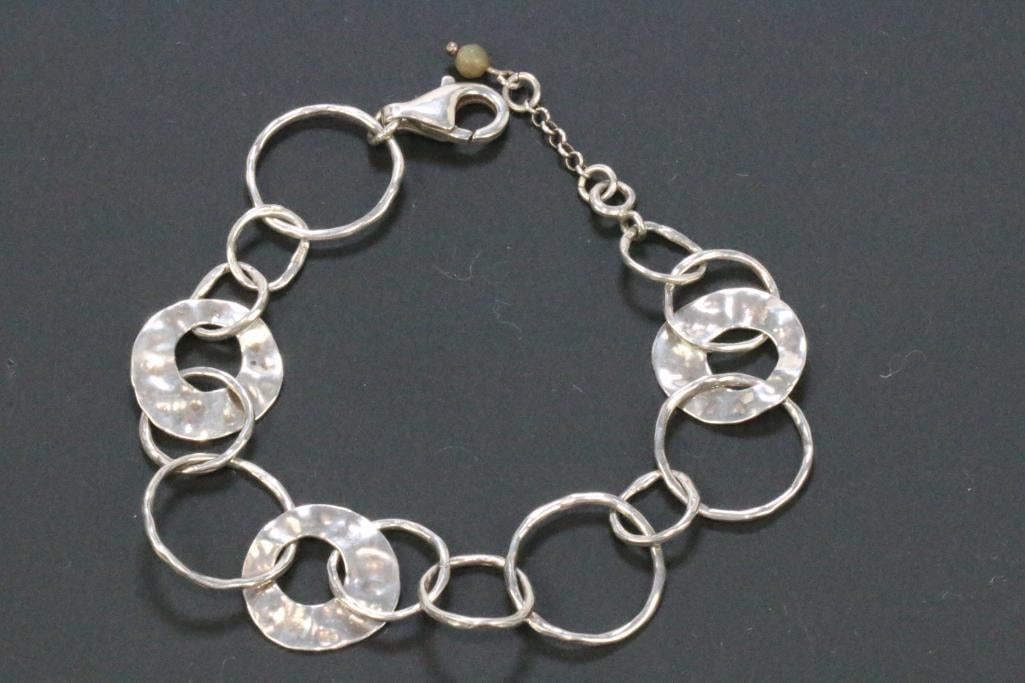 Sterling Silver Silpada hammered ring bracelet 13.6 grams.: Round and flat hammered disc ring bracelet by Silpada. Stamped SILPADA on one ring and 925 on the lobster clasp. Mearues: 7.5" to 8.5" with the chain extender. Rings are 7/8" diameter at the largest. 