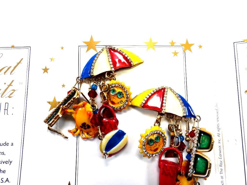 Lunch at The Ritz USA 22KT Gold Plated "Life's A Beach" Earrings: Amazing beach-themed clip on earrings with dangling beach-themed charms made with 22Kt Gold Heavy plating in the USA . Genuine Austrian Crystals. 2"x 3" long' Don't miss the matching pendant brooch in
