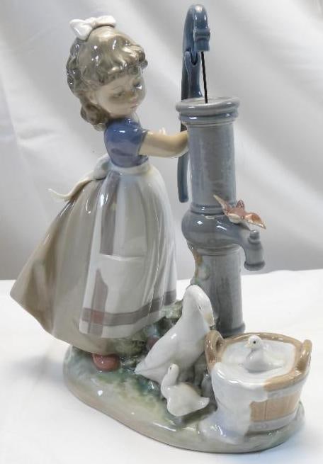 LLADRO Porcelain Figurine, "Summer on the Farm", SIGNED and NUMBERED: *CONDITION The metal piece at the top of the spout is inside the water “pump”. Lovely and detailed porcelain figurine of a young girl at a hand pump with geese, standing approximately 9.75" ta