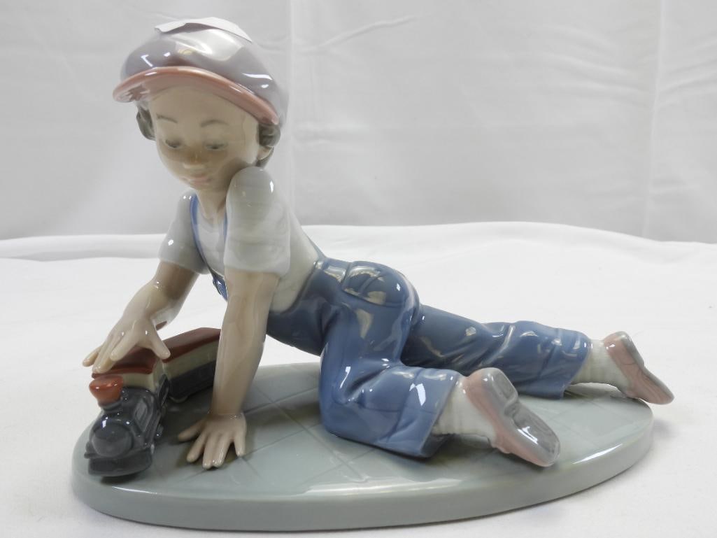 LLADRO Porcelain Figurine: Lovely and detailed porcelain figurine of a young boy with a train, 5" tall x 7.25" long, made in Spain, the figurine showcases the beautiful and delicate glossy transparent glazes Lladro is known for