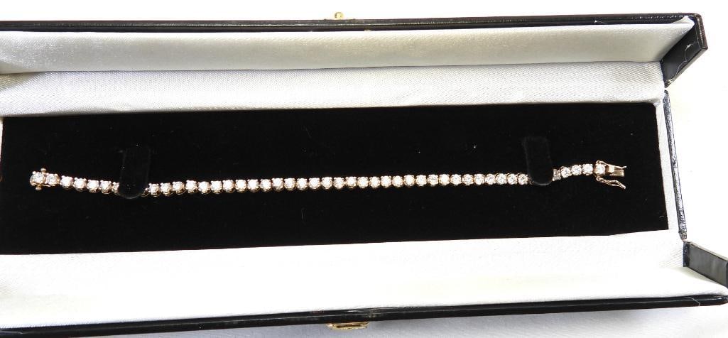 Gold over Sterling Silver Diamonique CZ Tennis bracelet.7": grams Each Faux diamonds with brilliant sparkle is approx. 3.7mm round. Fully faceted individually set gorgeous gold over Sterling silver, looks real! This is gorgeous! 7.5" long Presented in a black 