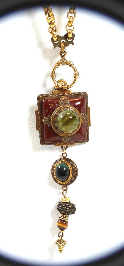 Designer Patrice Tigers Eye and Stone Necklace: An amazing necklace hanging a full 20" long with green gemstone set upon an etched deep oxblood red stone, with tigers eye dangling beneath; the details continue on the reverse side with embossed lotu