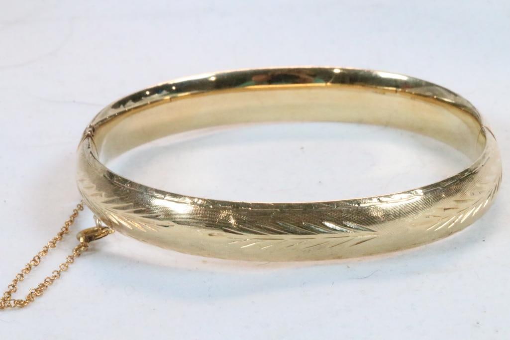 14 Kt Gold Etched gold cuff bracelet 11.1 grams: Hallmarked 14kt. Etched design. Slight ding on one side. Locking clasp with security chain. Measures: 3/8" wide x 2-3/8" wide inside