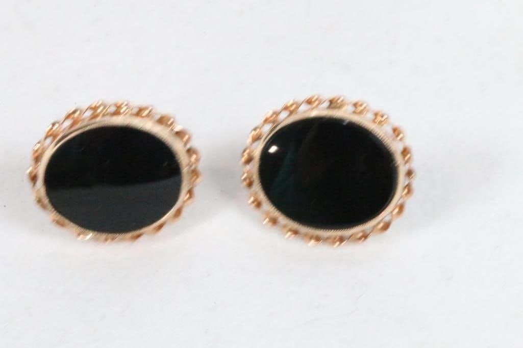 10kt gold black onyx post pierced earrings. 2.2 grams: Lovely gold rope surrounds the black onyx stone. Measures: 5/8" l x 1/2" wide . Screw back pierced posts. Missing one earring back.