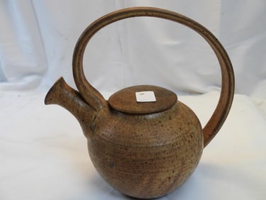 Vintage ceramic teapot, likely handmade, with a unique handle