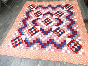 Patchwork quilt with peach floral print on outside, 81"x 84"