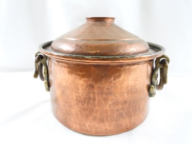 Vintage hammered copper pot with a lid and what appears to be brass handles