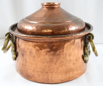 Vintage hammered copper pot with a lid and what appears to be brass handles