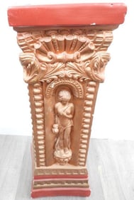 Decorative pedestal with red top and a classical design