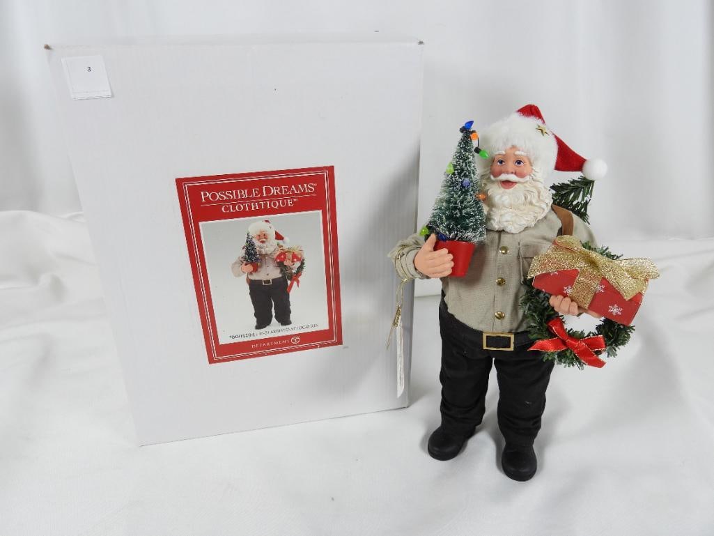POSSIBLE DREAMS CLOTHTIQUE 10-23 Arrived at Loc: DEPT 56 POSSIBLE DREAMS CLOTHTIQUE 10-23 Arrived at Location Santa holding present and potted tree and wreath, #6005294, new in original white box, 7"Lx6.5"Wx11.5"T