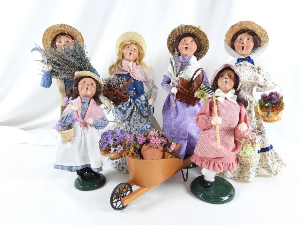 LOT OF 7 BYERS CHOICE Carolers/wheelbarrow signed: LOT OF 7 BYERS CHOICE Carolers: 2004 Girl Caroler with flower basket and rake, BYERS SIGNED, 4.5"Lx6"Wx10"T; 2002 woman caroler with blue floral dress, flower basket and watering can, CREATED especial