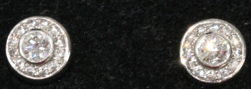 14kt white gold diamond earrings 4.2 grams: Large solitaire center diamond each earring approx. 6mm with 12 individually set 2.3mm diamonds in each earrings. Total diameter of the earrings are 11.34mm. These are stunning brilliant full cut diam