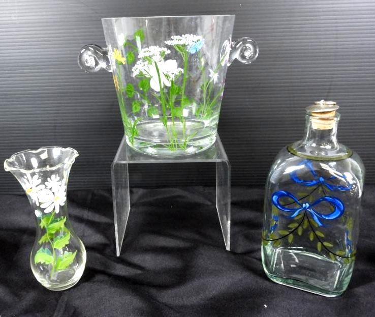 Lovely lot of 3 Hand painted glass Ice bucket, decanter and vase.: Stunning pants florals and ribbons on a 2 handled ice bucket that could also serve as a planter or dried glowers arrangement holder 6" high x 6" diameter with 2" swirled glass handles. 6" x 3" bud vas