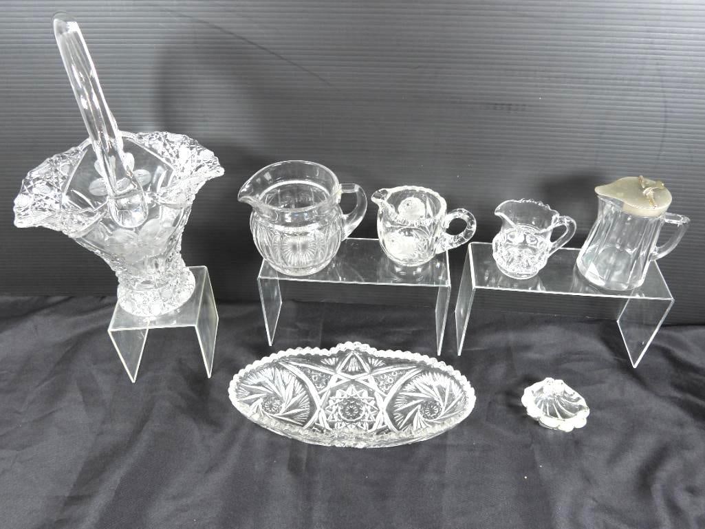 Lot of 7 Vintage Glassware and decor: Displayed are 4 pitchers, 1 serving tray and 1 glass basket about 12.5" all with a similar starburst pattern on their base plus a seashell themes dish