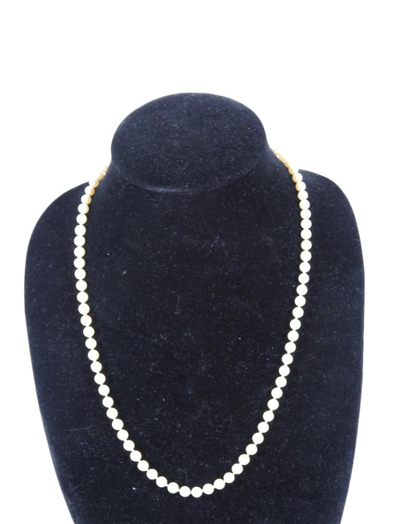 14kt Gold Genuine cultured pearl necklace: 14kt white gold hallmarked clasp. Genuine 5.9mm round cultured pearls hand knotted. 24" long. Comes in a velvet fabric presentation pouch.