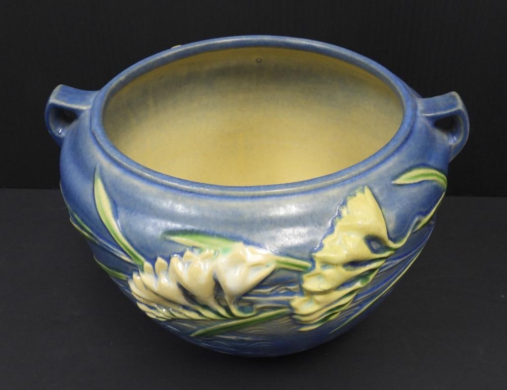 VINTAGE ROSEVILLE POTTERY VASE: Displayed in this lot is a blue Freesia Jardiniere vase likely produced in the 1940's featuring white sculpted freesia flowers model 669-6 9.5"x9"6"