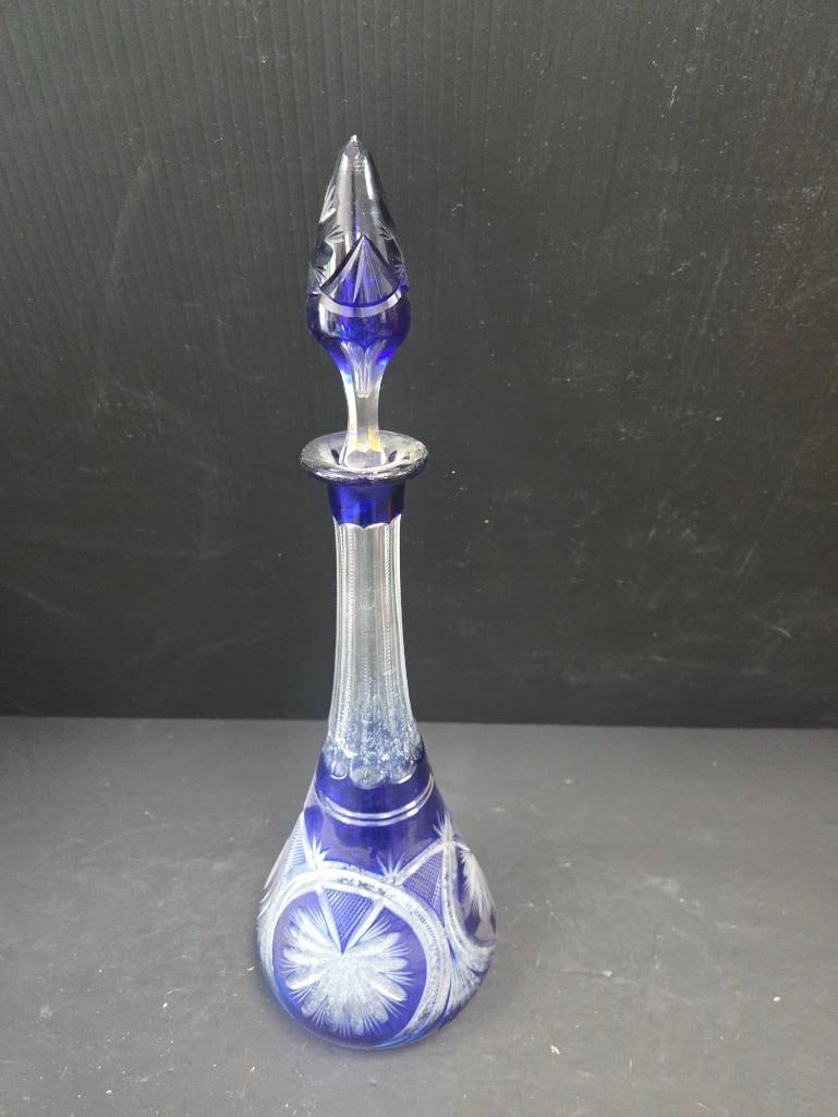 VINTAGE BOHEMIAN COBLAT BLUE CRYSTAL DECANTER: Decanter has blue glass overlay revealing clear crystal with flourish and starburst patterns on its face 6"x6"x17" (decanters stopper is broken inside the neck and will not come out)