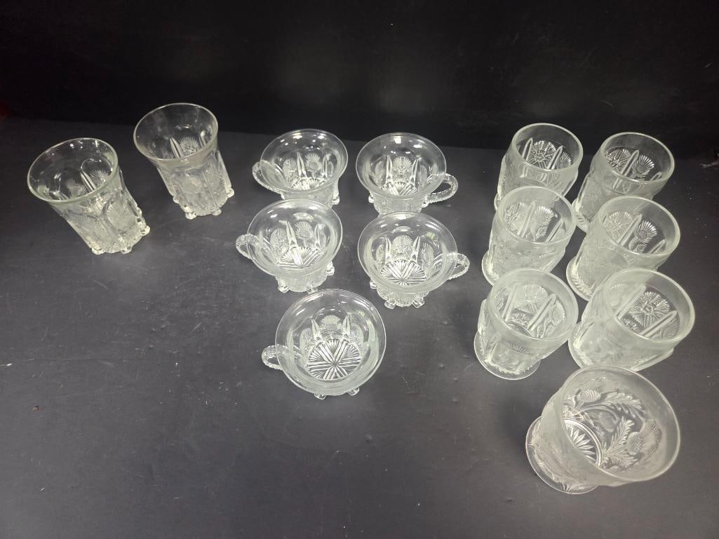 Mixed Grouping of Pressed Glass Tumblers and Punch Cups: 2 tumblers, plain paneled pattern (no thistle motif), footed. Approx. 4"H x 2.5"W each.7 tumblers, thistle pattern, footed. Approx. 4"H x 2.5"W each.5 punch cups, thistle pattern, applied handle,