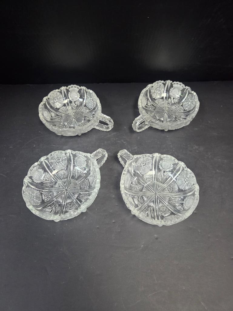 Set of Four Pressed Glass Thistle Pattern Handled Nut Dishes: Set of four matching small nut/candy dishes, thistle pattern, single tab handle, scalloped rim. Approx. 1.5"H x 4"W each.