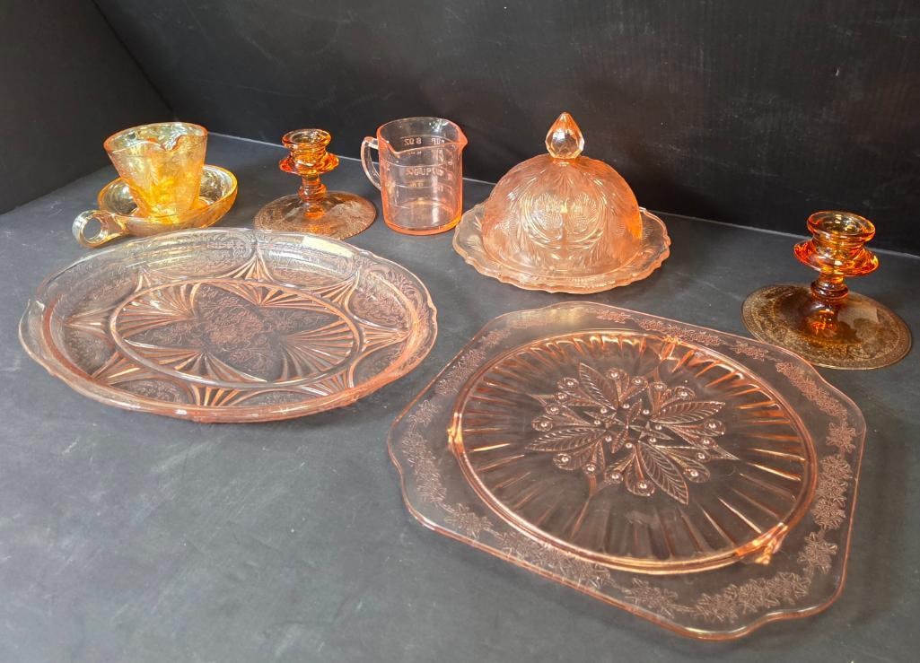 Mixed Grouping of Pink Depression Glass: Cup and saucer, amber/pink glass, etched pattern. Approx. 3"H (saucer 5.5"W).Candlestick, pink glass, single stem. Approx. 3"H.Candlestick, amber glass, matching form but a different color from the