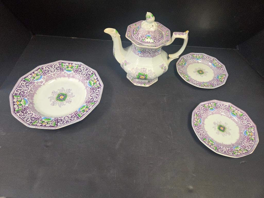 Purple Floral Transferware Tea Set, Four Pieces: Octagonal ironstone teapot with domed lid and knob finial in a lavender/purple scroll-and-floral transfer pattern with green leaf accents, together with three matching plates in the same pattern (one 