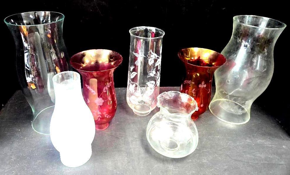 Assorted Glass Hurricane Shades and Vases, Seven Pieces: Clear pressed glass hurricane shade of flared bell form, approx. 10" H; white satin glass bulbous shade, approx. 8" H; cranberry glass shade with white floral etching, approx. 8" H; clear glass cylind
