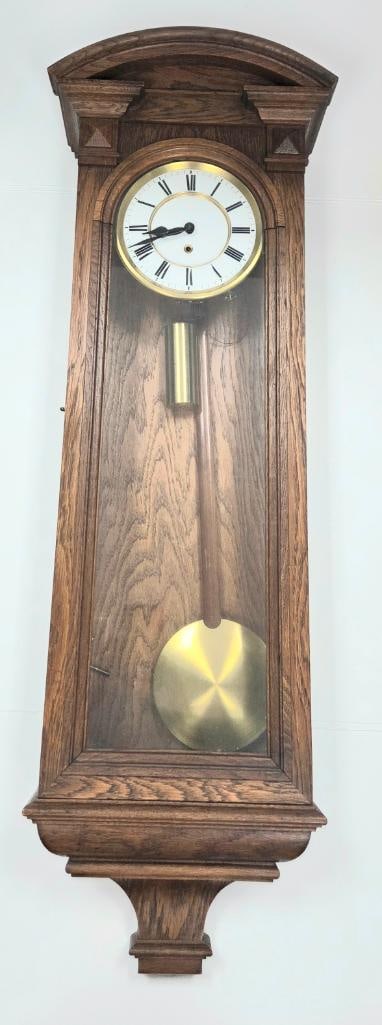 Oak Vienna-Style Regulator Wall Clock: Antique oak Vienna-style regulator wall clock, arched pediment with molded cornice, white enamel dial with Roman numerals and brass bezel, glazed side panels, brass pendulum bob, glass door shown open