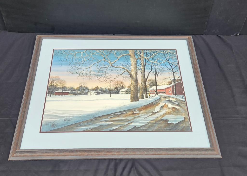 Framed Watercolor of Snowy Country Road with Red Barn: Framed watercolor painting of a snow-covered country road at dusk, large bare trees in the foreground, a red barn and white farmhouse in the distance, pastel sunset sky, wood-tone frame with double