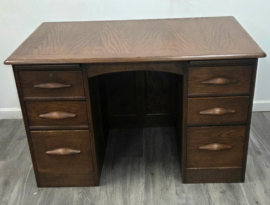 Oak Double-Pedestal Kneehole Desk: Antique oak double-pedestal kneehole desk, six drawers total (three per pedestal) with diamond-shaped wood pulls, one drawer with keyhole escutcheon, arched kneehole apron, approx. 48" W x 24" D x