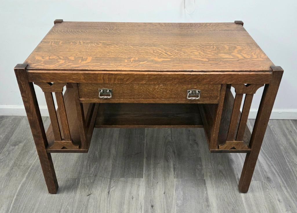 Mission Oak Library Table/Writing Desk: Arts and Crafts/Mission-style quartersawn oak library table or writing desk, single center drawer with hammered-metal bail pulls, pierced side stretchers with a lower shelf, square tapered legs,