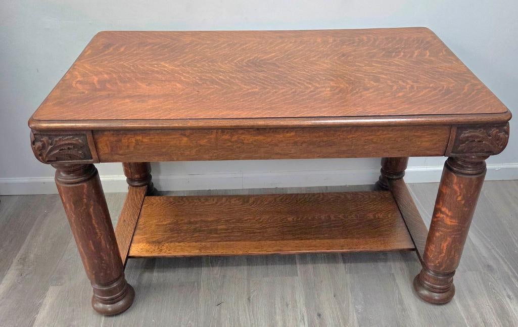 Quartersawn Oak Library Table with Carved Acanthus Brackets: Quartersawn oak library table, single drawer, carved acanthus-leaf corner brackets, turned and reeded column legs on bun feet, lower shelf, approx. 46" W x 26" D x 30" H.
