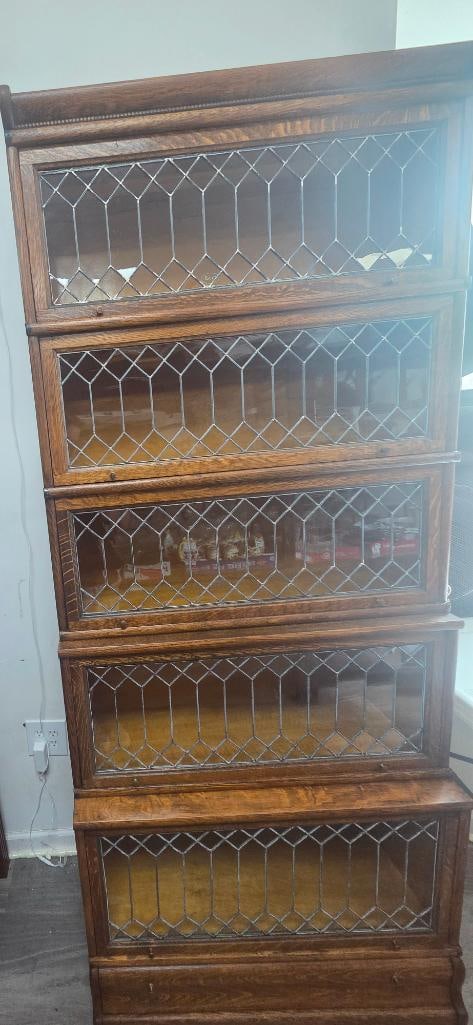 Oak Stacking Barrister Bookcase with Leaded Glass Doors: Antique oak stacking barrister/lawyer's bookcase, seven sections, each with a lift-up leaded diamond-and-hexagon glass door, molded cornice top and base, approx. 60" H x 34" W x 12" D.