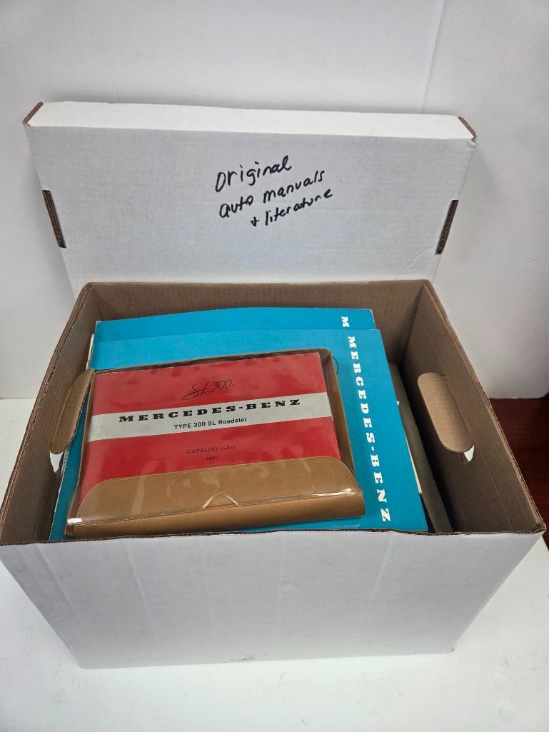 Box of Original Mercedes-Benz Sales Catalogs and Owner's/Workshop Manuals: Box labeled "Original Auto Manuals + Literature" containing a group of original Mercedes-Benz publications: a red and white "Mercedes-Benz Type 300 SL Roadster" sales catalog in a clear presentation s