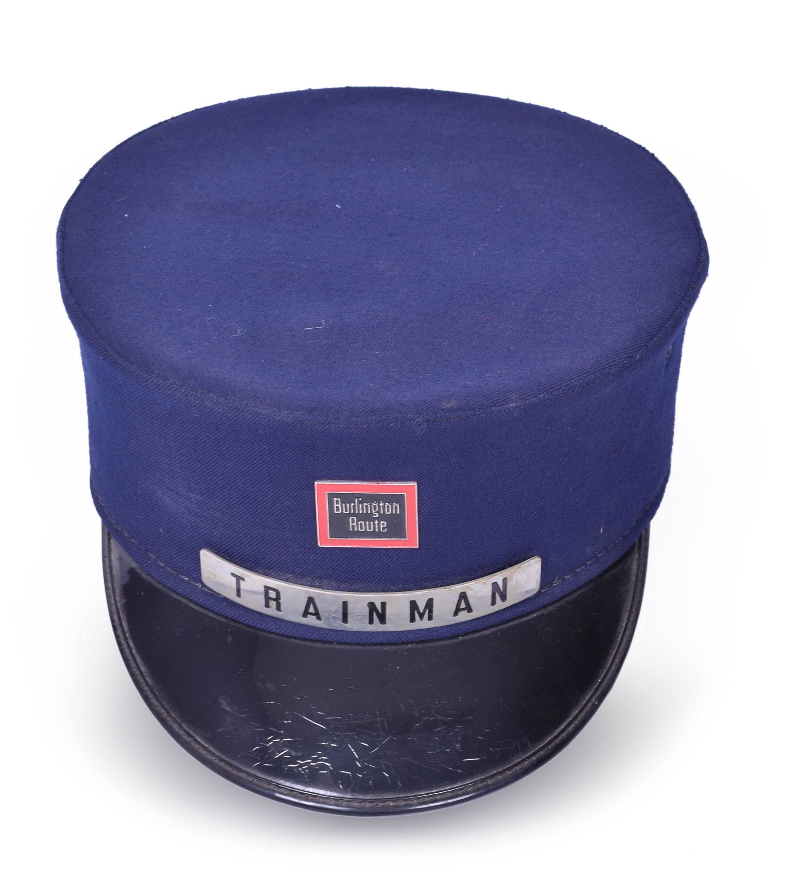 Carlson & Company CB&Q / Burlington Trainman Cap: Carlson & Company CB&Q / Burlington Trainman Cap Includes both the Trainman and Burlington Route badges with strong enamel backgrounds. Size is 7 1/8 and has the Carlson and Company makers information