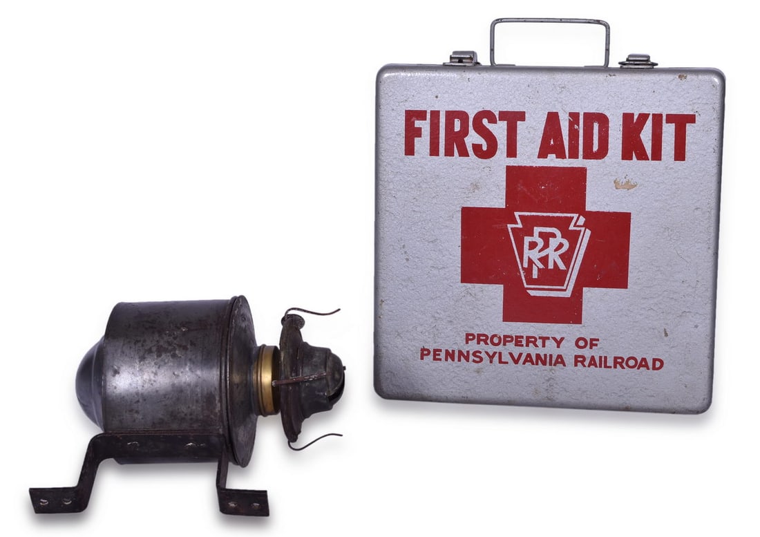 Pennsylvania Railroad Partial Wall Lamp and First Aid Kit: Two items for the Pennsylvania Railroad including a partial wall lamp embossed on the front with the PRR keystone logo Johnson Urbana. The lamp is missing the glass but retains the burner pot and foun