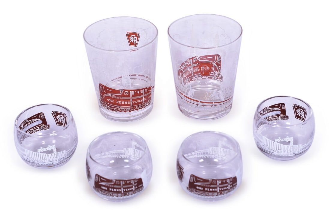 Six Pennsylvania Railroad Glasses - Roly Poly and Low Ball: A group of six Pennsylvania Railroad drinking glasses. Includes four 2 1/4" roly-poly style glasses with Keystone logo in dark red and 4902 train graphic, showing minimal signs of use. Two high ball g